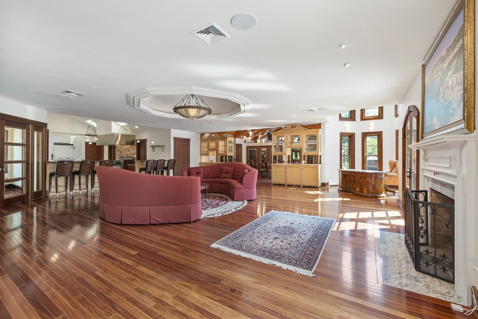Cozy modern interior design of a living room with laminate flooring and a red couch in a mansion